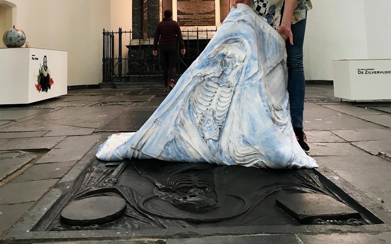 Afgieten van Magere Hein van een graftegel in de Kerk (foto: Nynke Koster)