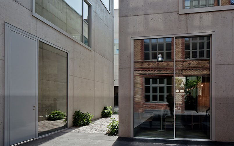 De grote glaspuien in de massieve betonwanden weerspiegelen het metselwerk van de oude pianofabriek. (Foto: Ute Zscharnt i.o.v. David Chipperfield Architects)