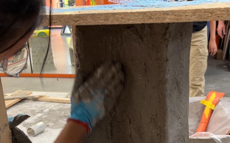 Het pleisteren van een textiel gaas met een stroperig betonmengsel (foto: Tektoniek)