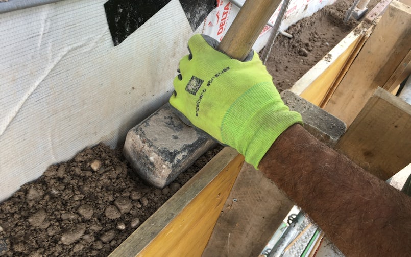 De kleine grindnesten die her en der ontstaan geven die typische eigenheid aan stampbeton. "Het aanbrengen is een kwestie van leren aanvoelen: niet te veel stampen, want dan verlies je grindnestjes. En als je te lang aanstampt, wordt de laag te glad" (foto: DMOA architecten)