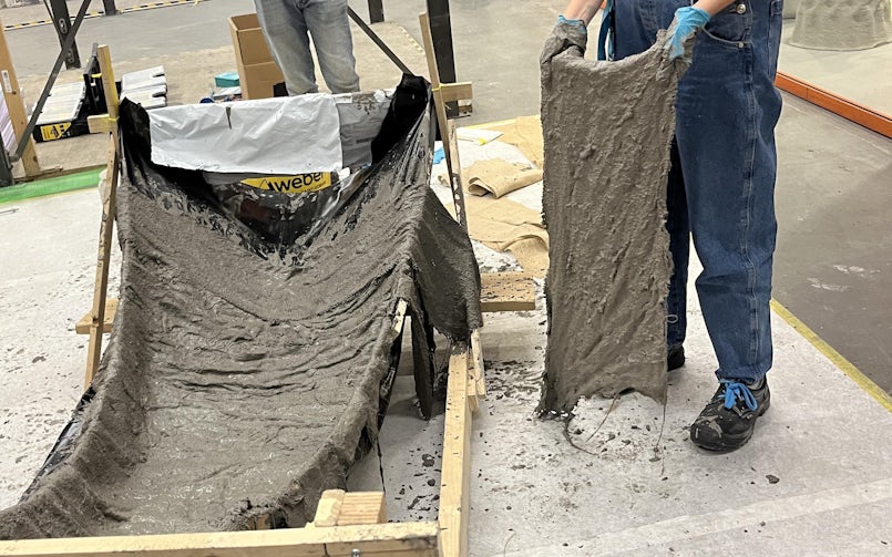 Het behangen van een textiele mal met in beton gedrenkte jute (foto: Tektoniek)