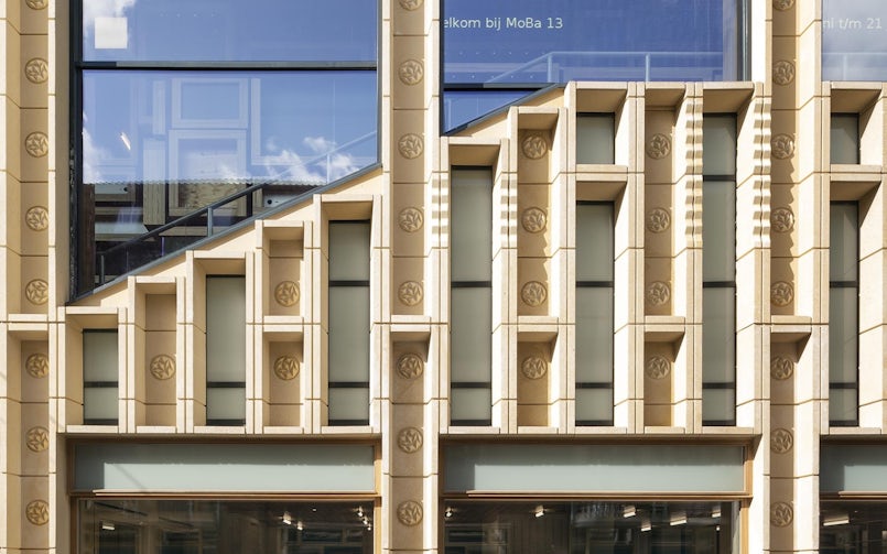 Het gebouw in Arnhem ontleent zijn naam aan de rozetten in de zachtgele betonpanelen (foto: Scagliola Brakkee)