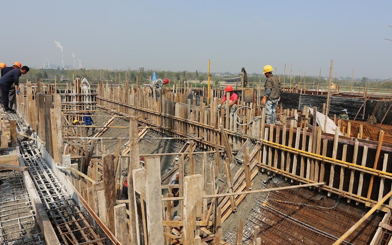 Het beton wordt aardvochtig aangebracht op de binnenkant van de schaalvorm (foto: MORE Architecture)
