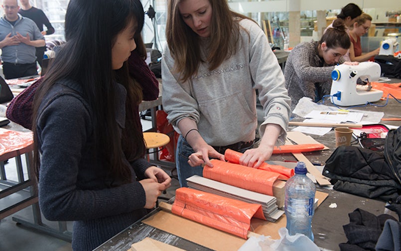 Samenwerking aan tafel met mallen en materialen – creatieve workshop betonvormgeving voor studenten.