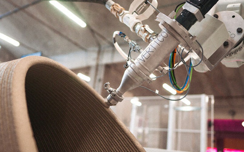 Een robotarm kan de printerkop in allerlei richtingen bewegen en kan zo ook op een schuin vlak printen. Vertico maakt gebruik van twee-componenten, waarbij een verharder in de printerkop bij de betonmortel wordt geïnjecteerd (foto: Vertico)